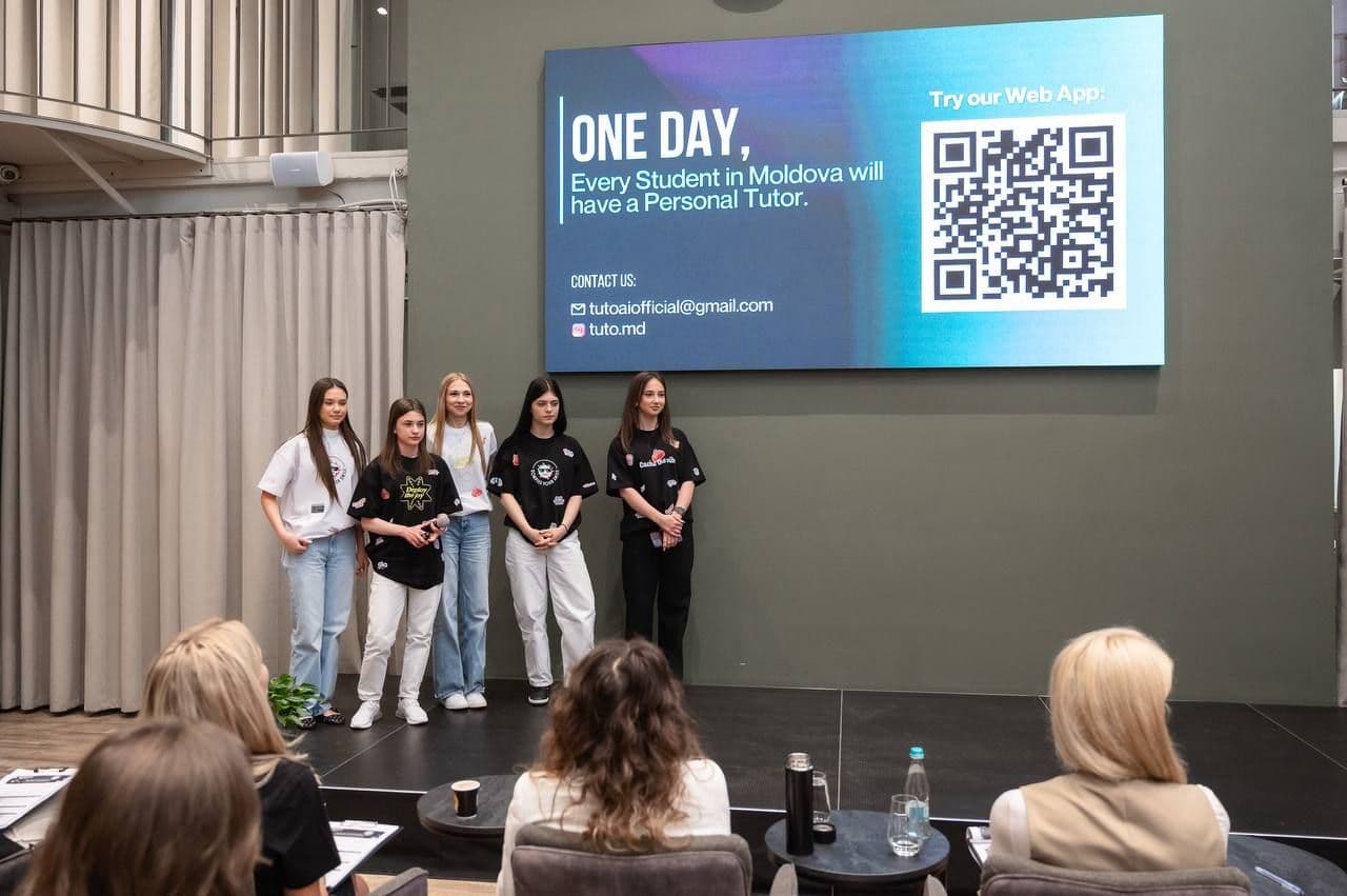 Echipa pe scenă, în fața ecranului cu textul „One day, every student in Moldova will have a personal tutor” și un cod QR