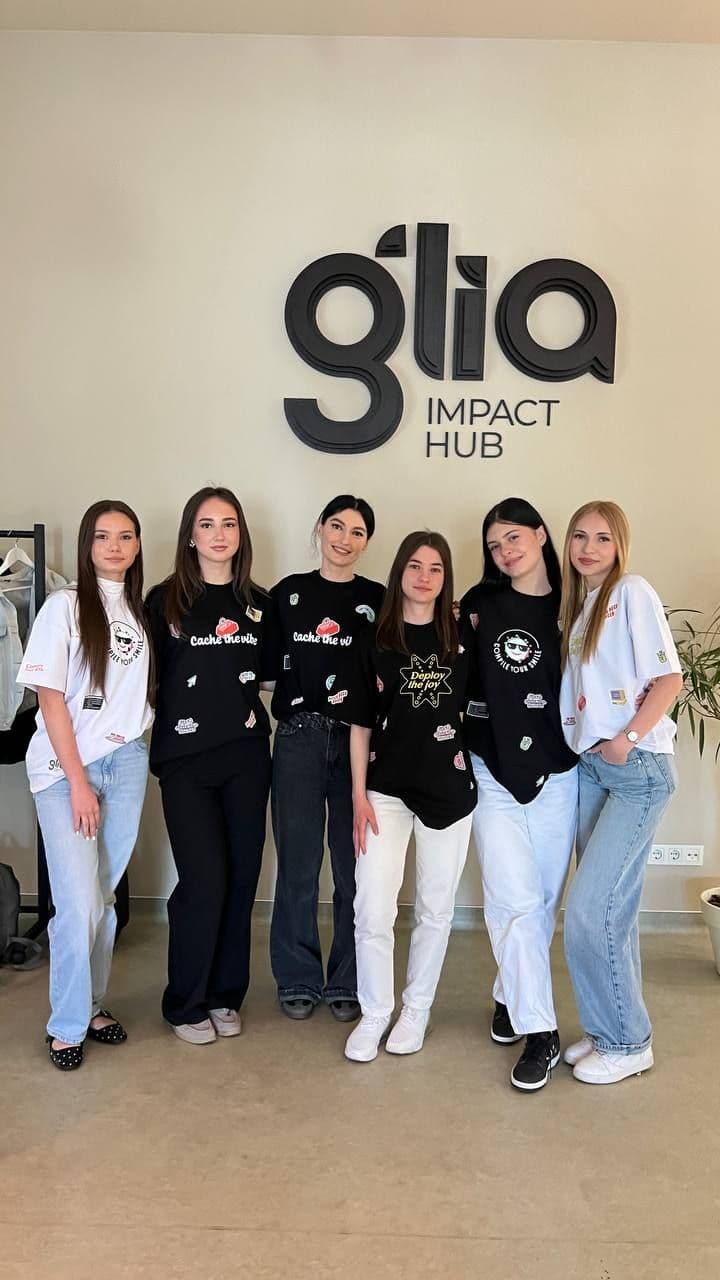 Șase membre ale echipei în tricouri Tuto, în fața logoului Glia Impact Hub